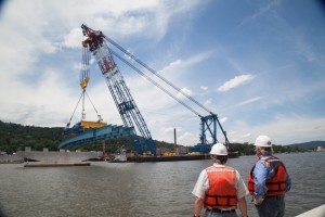 Project executives look on as the new bridge’s first girder as